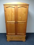 A pine double door wardrobe fitted a drawer