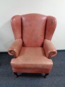 A red leather wing backed armchair