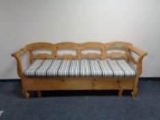 A pine storage settle with cushion