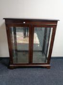 A contemporary mahogany display cabinet on bracket feet