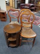 A circular oak three tier book table together with three bedroom chairs
