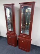 A pair of mahogany effect corner display cabinets fitted with cupboards and drawers