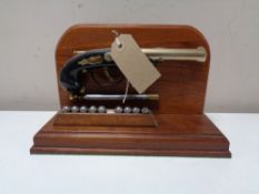 A lighter in the form of a flintlock pistol on wooden stand