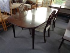 A mid century extending oval dining table and four chairs.