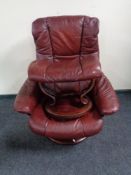 A maroon leather Stressless swivel adjustable armchair with stool