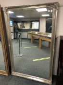 A silvered swept framed mirror 103 cm x 167 cm.