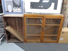 A glazed kitchen cabinet together with a further wooden bookcase