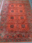A machine made woolen rug on red ground