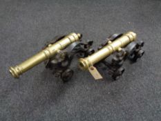 A pair of brass cannons on ornate cast iron bases depicting dragons