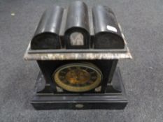 An antique black slate mantel clock with brass dial