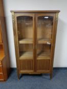 A twentieth century inlaid mahogany double door display cabinet with gilt brass mounts