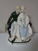 A Keramos figure group of a seated couple, after a design by Rudolf Podany, signed to base.