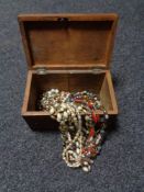 An antique inlaid wooden jewellery casket containing beads, necklaces,