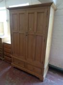 A pine double door wardrobe fitted with two drawers
