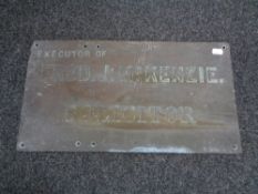 An antique brass Fred J McKenzie solicitor's wall plaque