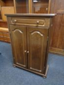 An oak double door cabinet on bun feet