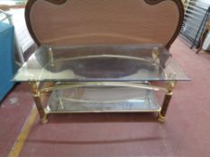 A contemporary glass topped coffee table with mirrored undershelf