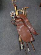 A leather gun bag containing assorted walking and shooting sticks