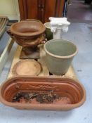 A pallet of garden planters and pedestals