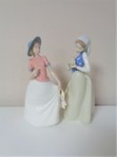 Two Nao figures - girl with chick and girl holding flower