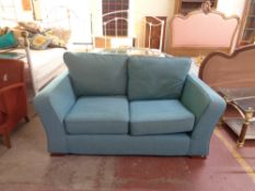 A two seater settee in turquoise fabric