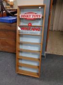 A glazed door wall cabinet bearing Dinky Toy advertising