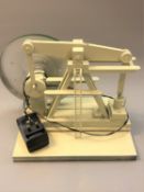 A wood and metal electric-driven derrick-type machine, height 30cm.