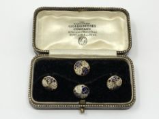 A set of 4 gold white and black enamel studs, 4.25g.