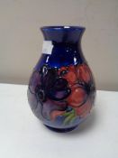 A Moorcroft vase, anemone flowers on dark blue ground, height 13.5 cm.