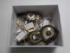A box of horse brasses some on leather straps