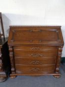A 20th century carved oak bureau on bun feet