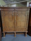 A 20th century oak double door cabinet on raised legs