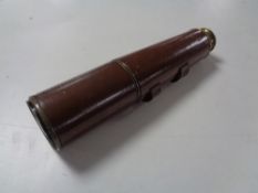 An antique brass leather bound nautical telescope.