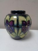 A Moorcroft vase, Art Deco design on dark green ground, height 9.2 cm.