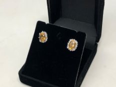 A pair of diamond and citrine cluster earrings