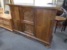 A 20th century carved oak triple door sideboard