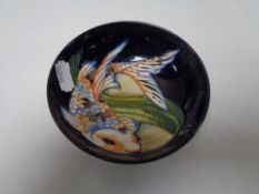 A Moorcroft shallow bowl, decorated with Koi carp on blue ground, width 11.5 cm.