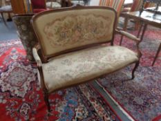 A continental beech framed settee in tapestry fabric