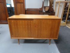 A mid 20th century beech sliding door sideboard 46 cm x 137.5 cm x 87 cm.