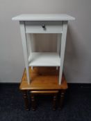 A pine lamp table fitted with a drawer together with a nest of two pine tables