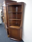 An Ercol elm corner cabinet fitted with shelves