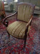 An antique mahogany scroll armchair