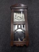 A 20th century oak eight day wall clock with pendulum and key