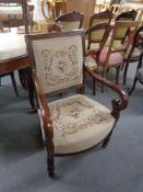 An antique mahogany scroll arm armchair