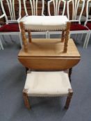 A blonde oak drop leaf coffee table and two dressing table stools