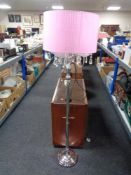 A contemporary metal four-way floor lamp with glass drops and pink shade