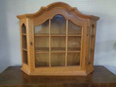 A blonde oak single door wall cabinet