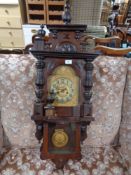 An mahogany wall clock with brass dial