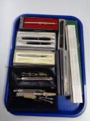 A tray of cased drawing instruments, slide rule, pens, Papermate, Parker,