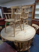 A pine farmhouse circular dining table and six antique style chairs